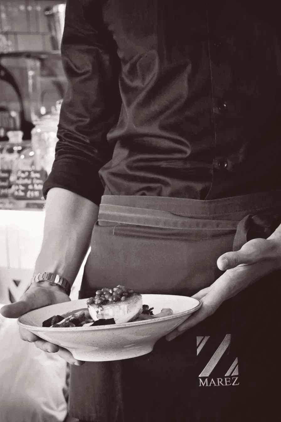 A Marez server carrying a plate to the table