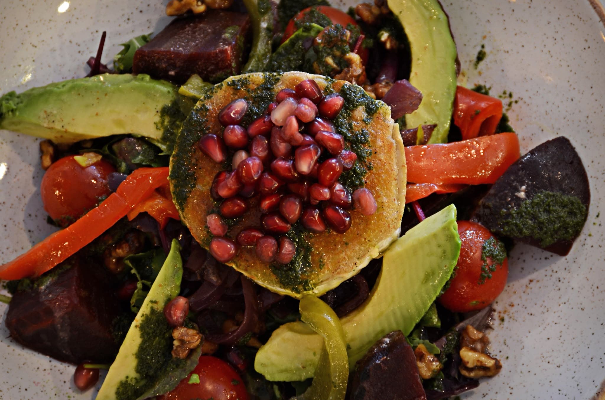 Warm goat cheese salad with beetroot, avocado and pomegranate